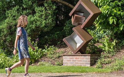 Woman walking past a sculpture outside