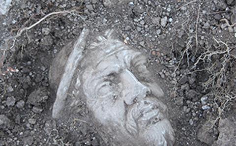 Image of stone head being dug up