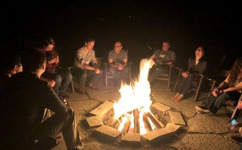 Students round campfire at summer school