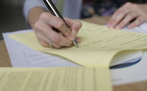 Person's hand writing on paper