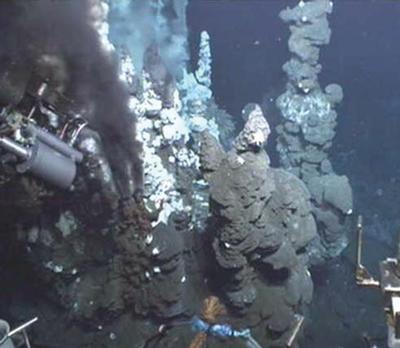 Black smoker chimneys spewing high temperature fluids on the E9 segment of the East Scotia Ridge. ROV ISIS titanium sampler shown