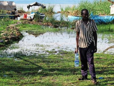 Fisherman in Arba Minch (Ethiopia) with a bottle of water extracted from a contaminated river