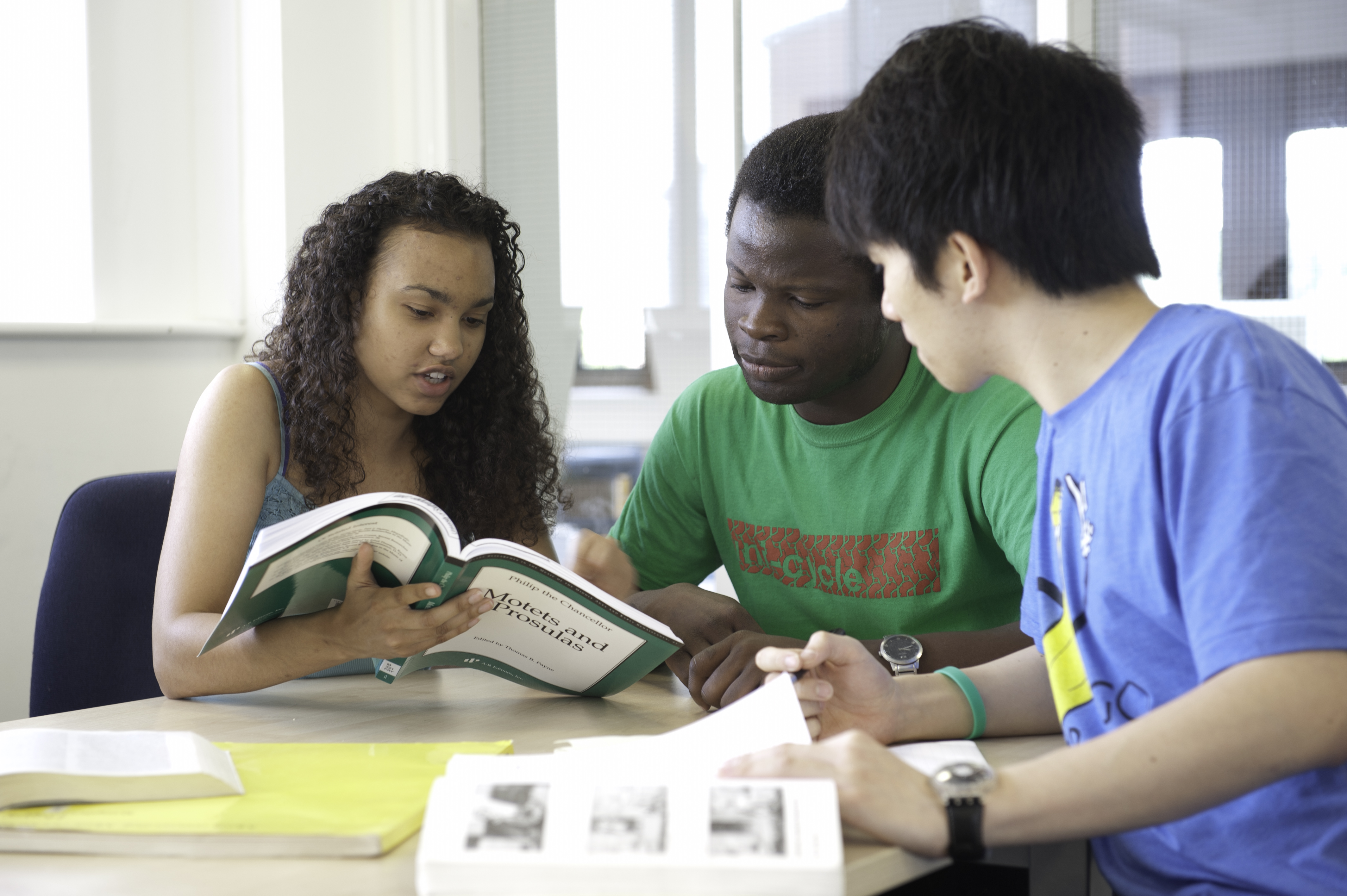 3 students reading a book in high resolution