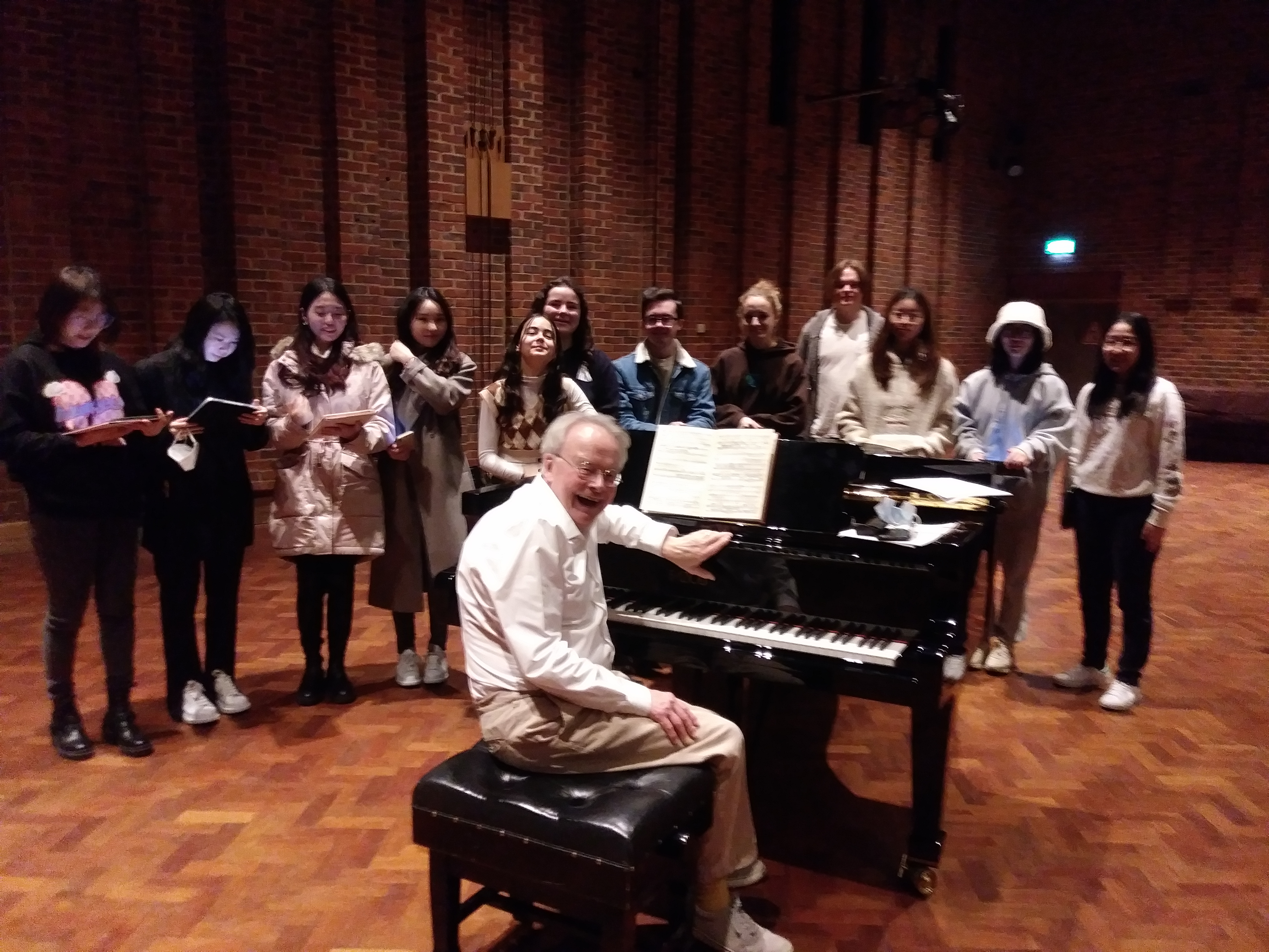 A piano, a pianist, and singers.