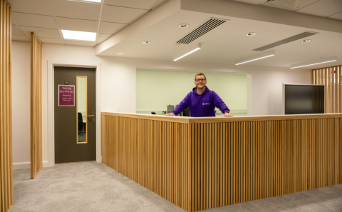 A colleague from the iSolutions Tech Hub behind the counter at the Sir James Matthews building Tech Hub
