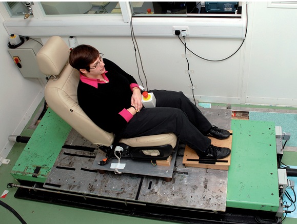 Participant seated on a vertical vibration platform used to study human response to whole-body vibration