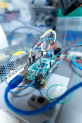 Electronics prototyping board with multicoloured wires connected on a laboratory workbench.