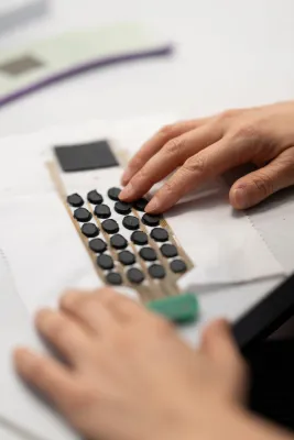 Hand testing a flexible textile sensor array made from circular conductive pads.
