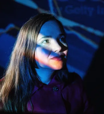 Portrait of Dr Larisa Yarovaya illuminated by coloured projected light.