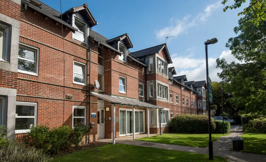 Exterior view of red brick, two storey accommodation building on a sunny day.