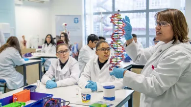 School children in lab coats learning in the Life Lab.