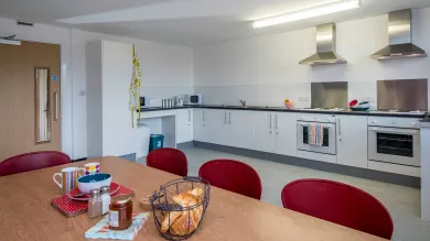 Large, empty modern kitchen with breakfast items on the table.