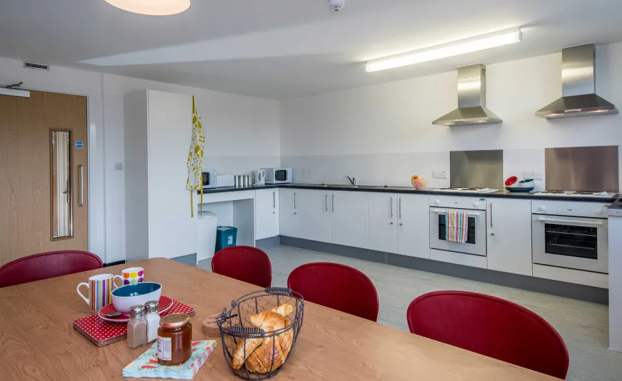 Large, empty modern kitchen with breakfast items on the table.