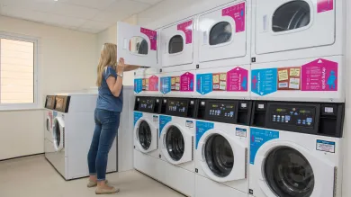 Student doing laundry in a communal laundry room.
