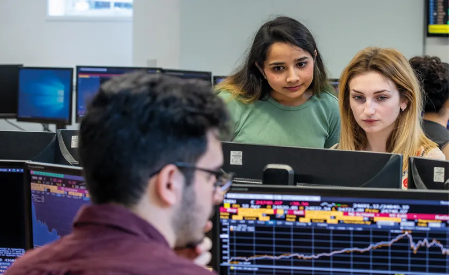 Business analytics degree students looking at Bloomberg screens