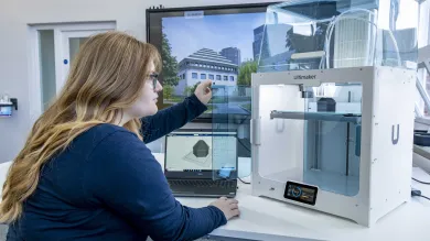 A student inspecting the finished construction of her latest 3D printed object.
