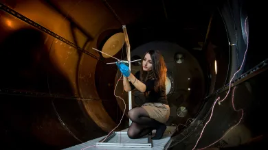 A student checks their experiment in the electric propulsion lab