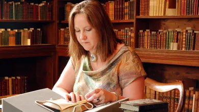 A postgraduate researcher studying a text at Chawton House library.