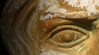Close up of an ancient artefact face carved in stone