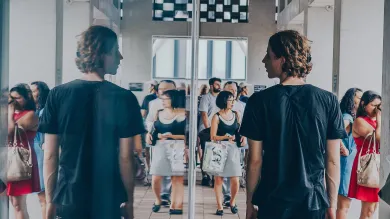 Man looking at his reflection in a window