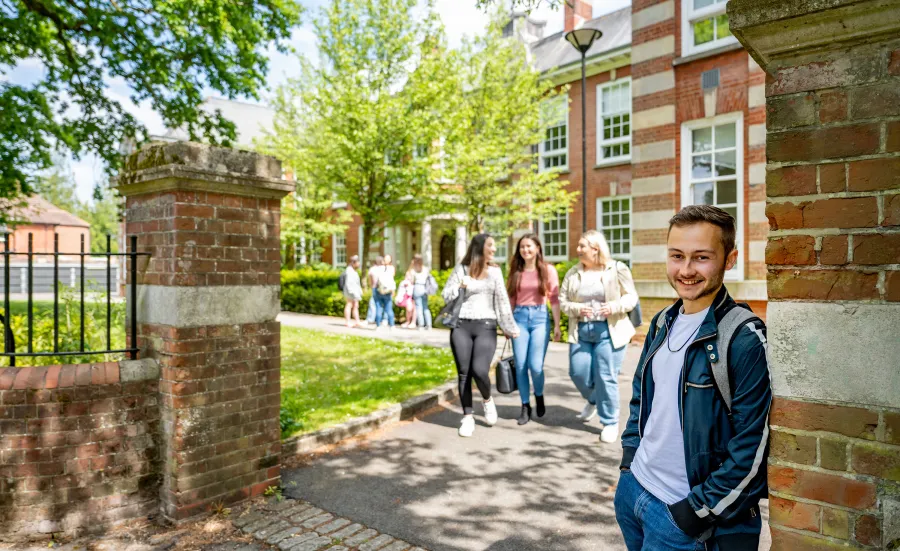 A student smiling at the gates of avenue campus