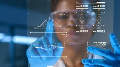 A researcher wearing blue medical gloves scrolls data on a screen