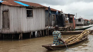 A resident of Ganvie stilt village in Benin navigates a boat through water