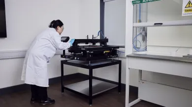 A woman researcher using a machine at the e-textile laboratory