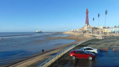 View of Blackpool Tower, beach and coastal defences on a sunny day.