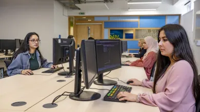 A group of economics students at work in the financial suite