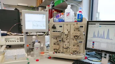 View of a bench with protein analysis equipment and computer screen showing results