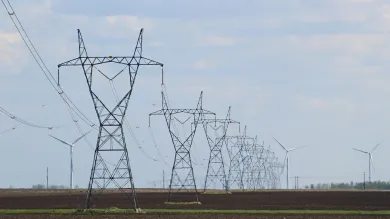 Transmission towers and wind turbines on a field