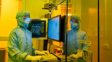A researcher in a cleanroom suit and wearing a protective glasses, uses the electron beam lithography (EBL) facility