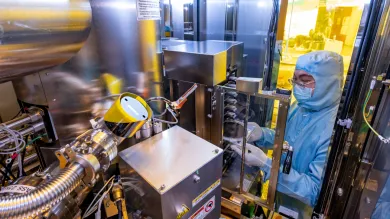 A researcher in a cleanroom suit inside the electron beam lithography (EBL) tool - the JBX-8100 G3 
