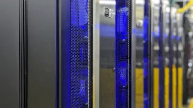 The IRIDIS 6 research computing facility. A series of servers in silver casing with blue and yellow network cables in the background.