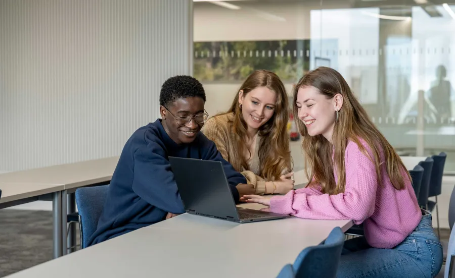Marketing students gathered round a laptop