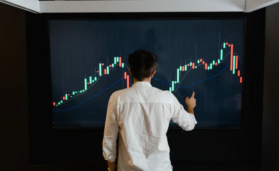 A person looking at a wall screen showing a colourful data blocks and line graph