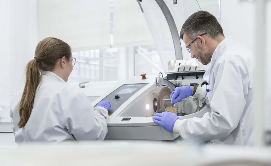 2 researchers placing samples in a scintillation counter.
