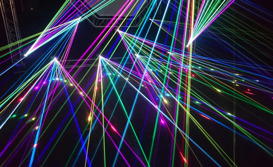 Colourful laser beams intersecting against a dark background.