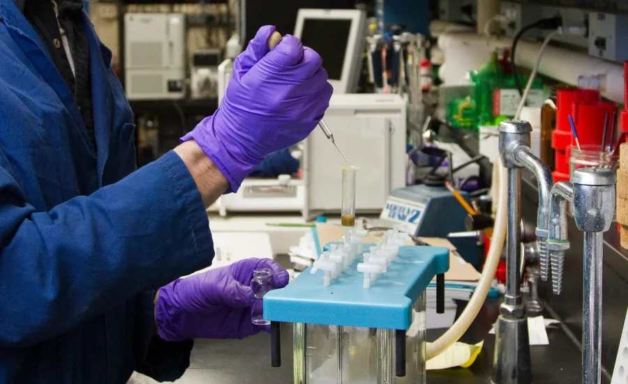 A scientist injects a test tube with fluid