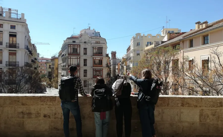 Beth and 3 of her fellow students, on a balcony looking out at Alicante buildings.