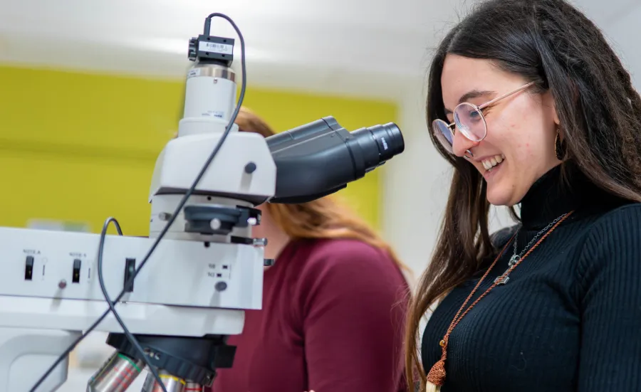 Archaeology student looking through microscope