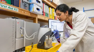 Scientist leaning over lab equipment