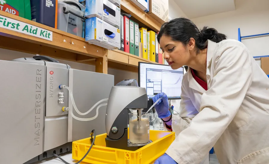 Scientist leaning over lab equipment