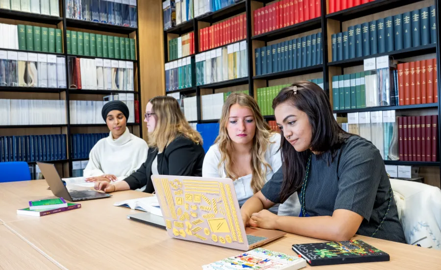 Students sat at table in library