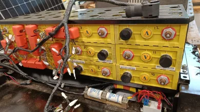 A battery bank setup with yellow cells, silver terminals, and connected wires