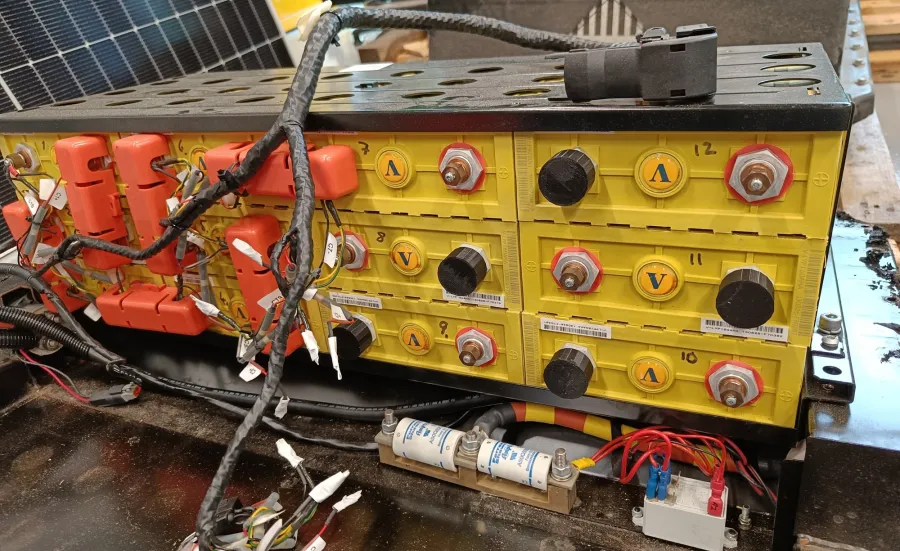 A battery bank setup with yellow cells, silver terminals, and connected wires
