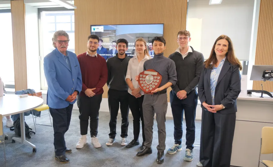 Undergraduates from the Southampton Business School standing in a line with the winners shield at the 2025 Universities Business Challenge.