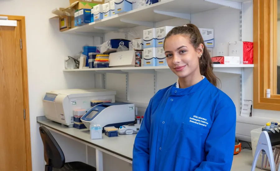 Amelia Milkins standing in front of shelves in the lab