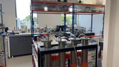 One of the rooms at the environmental laboratory with equipment, shelves, and a trolley with metallic cylinders.